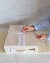 Load image into Gallery viewer, Person unzipping a beige bed sheet organiser box 