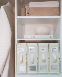 Wardrobe with bed sheet organisers labeled for different bed sizes, decorative items on shelves