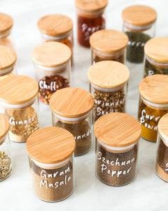 Glass and bamboo herb and spice jars used to store packets of herbs and spices in the kitchen