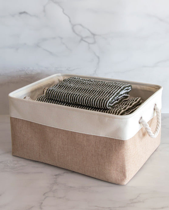 Beige and white storage basket made from linen with a cotton rope handle with towels inside