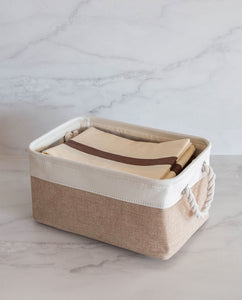 Beige and white storage basket made from linen with a cotton rope handle with pillowcases inside 