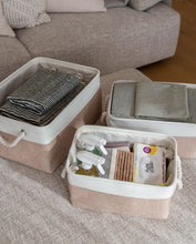 Load image into Gallery viewer, Set of three beige and white storage baskets made from linen with a cotton rope handle, in sizes small, medium and large 
