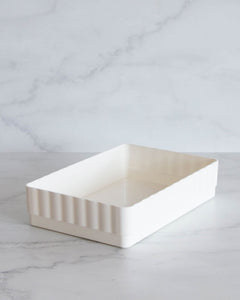 White bathroom container designed to fit in bathroom drawers and store toiletries such as skincare, makeup, haircare and perfumes