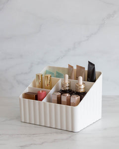 Tiered off white container with two small and two large compartments, used to store toiletries, stationary, or under sink items
